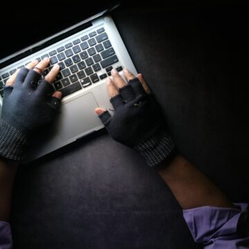 Hacker hand stealing data from a laptop